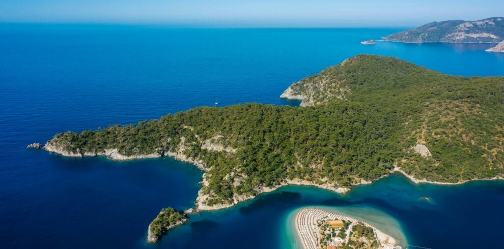 A stunning aerial view capturing the turquoise waters and lush greenery of a picturesque island with a sandy beach.